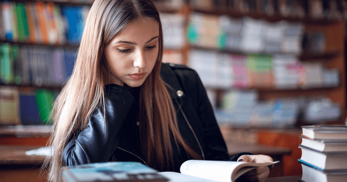 Mädchen liest ein Buch in einer Bibliothek